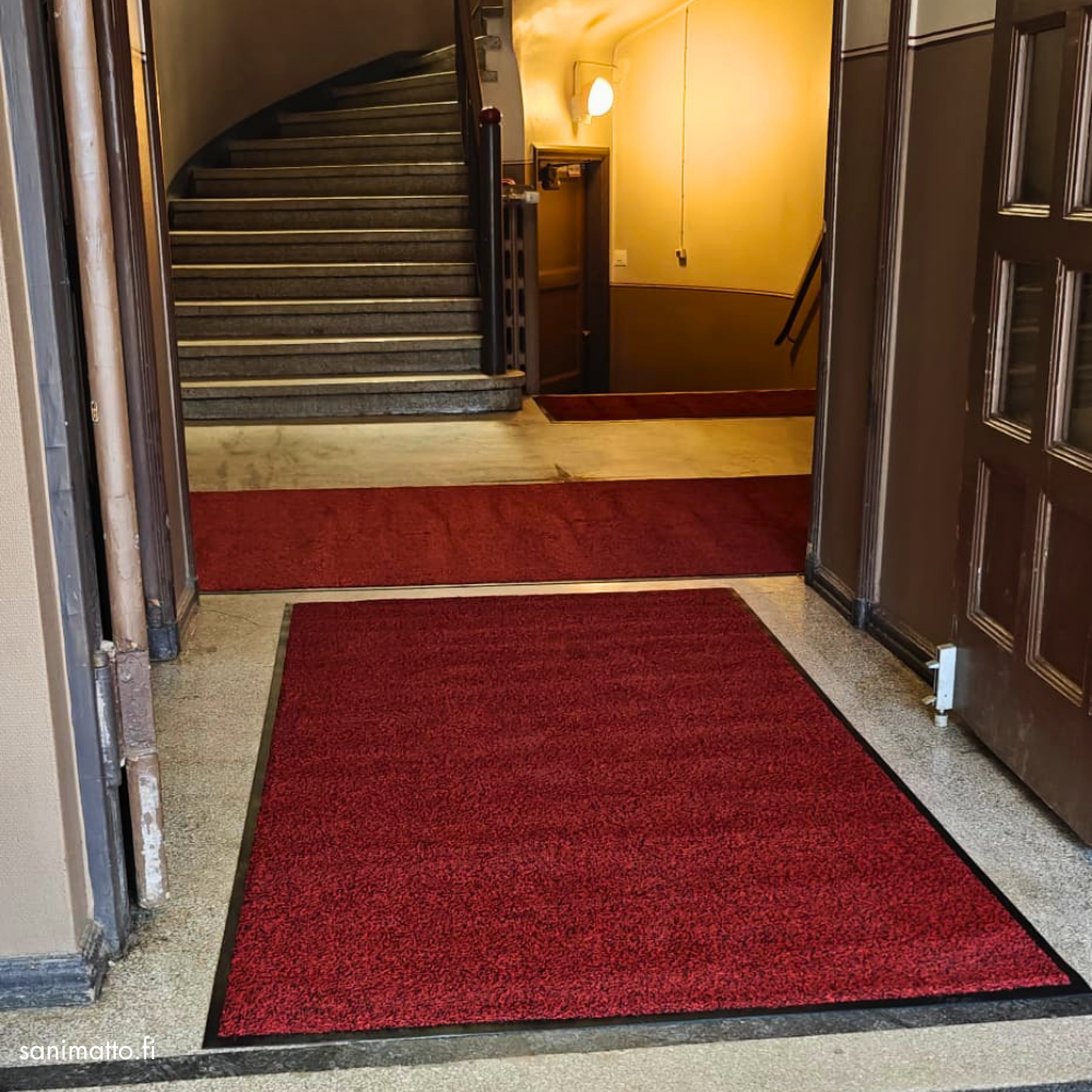 Punainen matto taloyhtiön sisäänkäynnissä